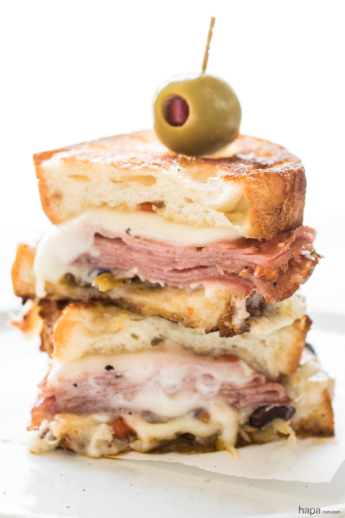 A Hot Muffuletta Sandwich dripping with cheese and packed with punch!