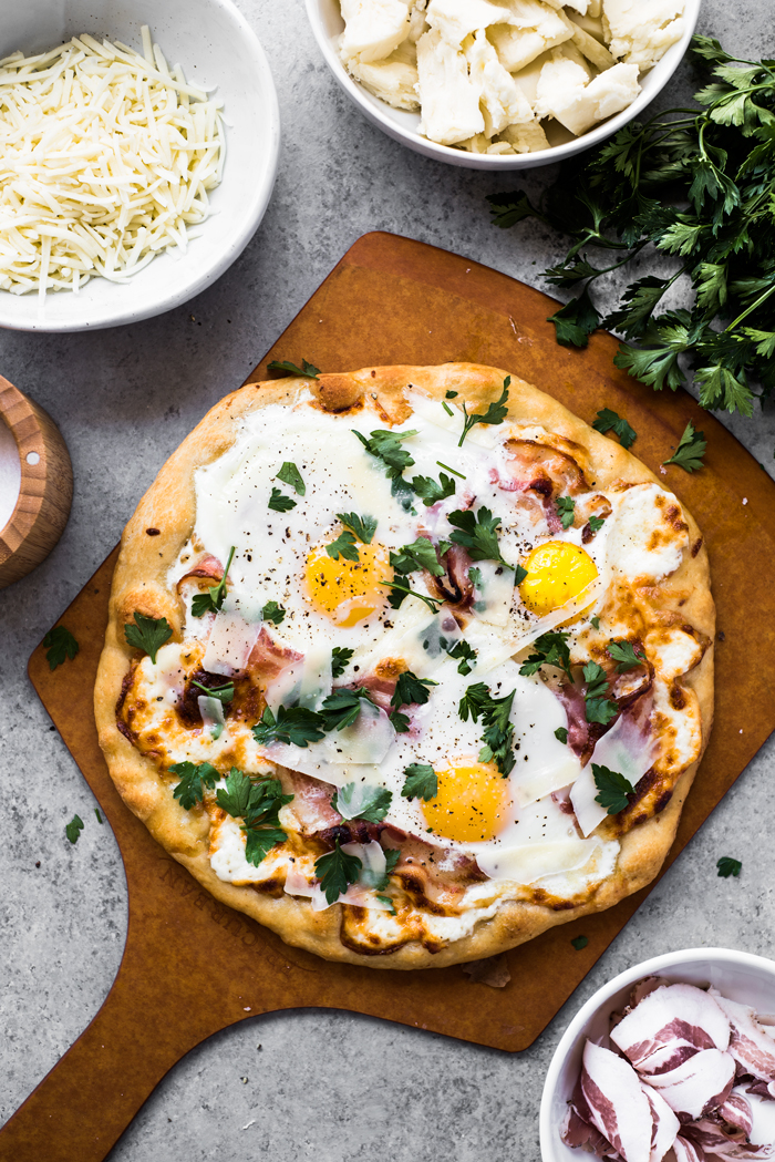 Roasted garlic, crispy pancetta, creamy sunny-side up eggs, and ooey-gooey cheese - makes this Pizza Carbonara irresistible! 