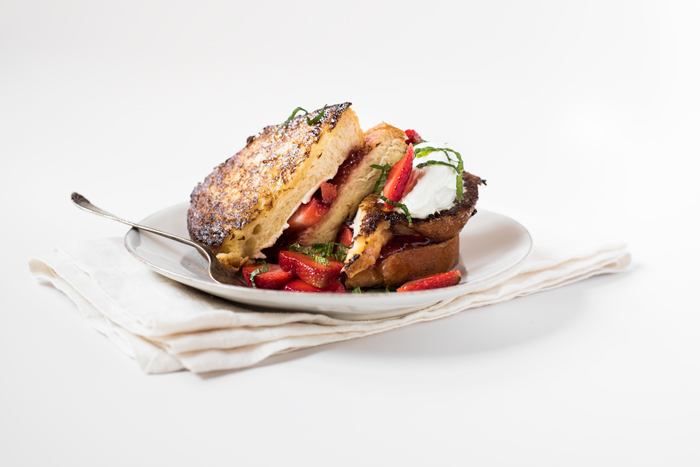 This French Toast sandwich (if you will), is stuffed with cream cheese, strawberry preserves, and macerated fresh strawberries. Topped with sour cream, more strawberries, and fresh mint – it’s like an orgasim in your mouth!