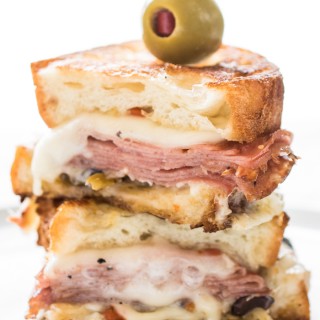 A Hot Muffuletta Sandwich dripping with cheese and packed with punch!