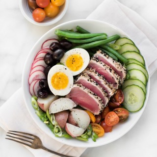 Perfectly seared sesame crusted ahi tuna on a bed of fresh veggies, topped with a creamy egg, and drizzled with a finger-licking good vinaigrette, gives this Nicoise Salad a 'WOW' factor!
