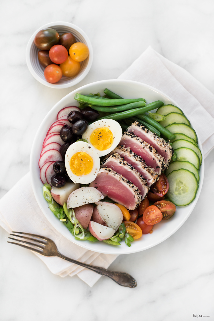 Perfectly seared sesame crusted ahi tuna on a bed of fresh veggies, topped with a creamy egg, and drizzled with a finger-licking good vinaigrette, gives this Nicoise Salad a 'WOW' factor!