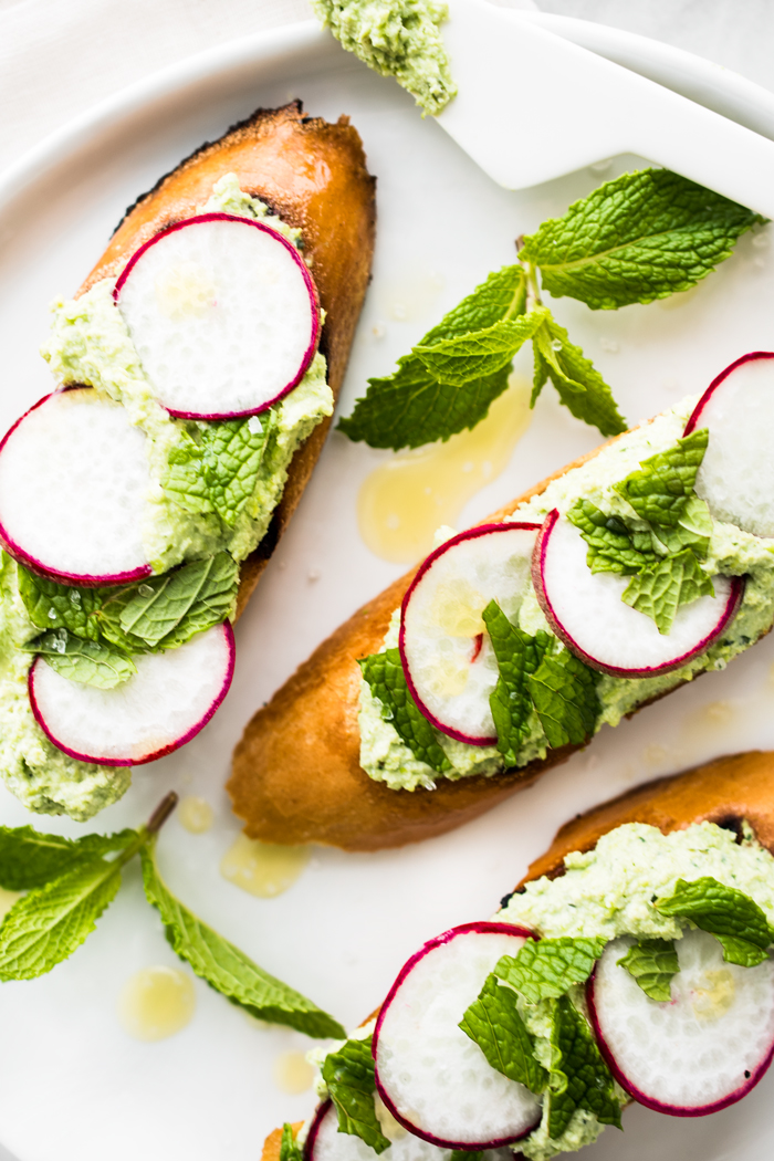 Edamame & Ricotta spread with thinly sliced radishes, mint, and sea salt on toasted bread. Ready for snacking in about 10 minutes! 