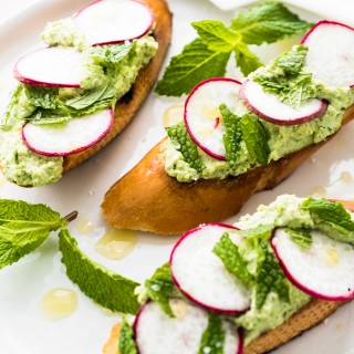 Edamame & Ricotta spread with thinly sliced radishes, mint, and sea salt on toasted bread. Ready for snacking in about 10 minutes!