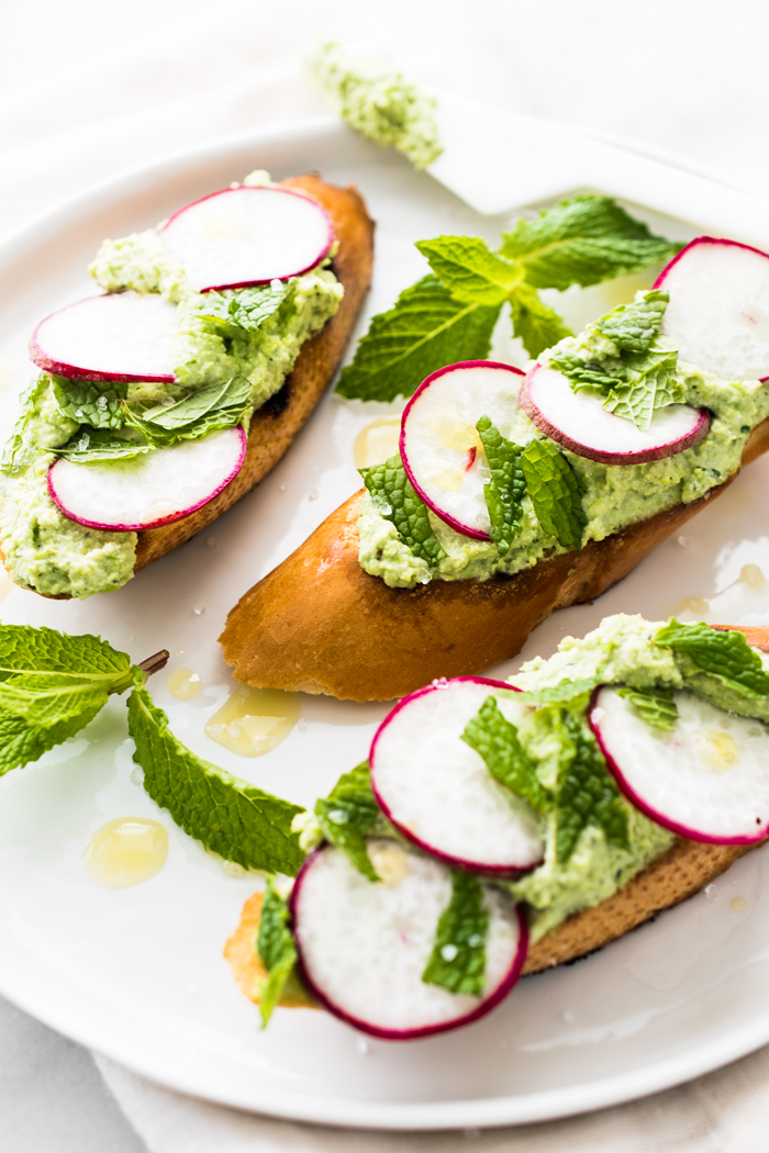 Edamame & Ricotta spread with thinly sliced radishes, mint, and sea salt on toasted bread. Ready for snacking in about 10 minutes! 