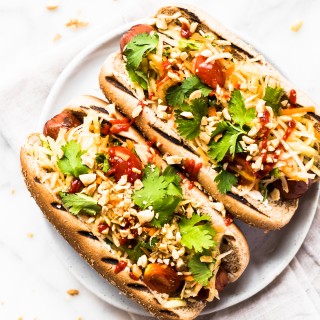 These Thai Style Hot Dogs are a fantastic twist on an American classic. Topped with cool papaya salad, crunchy peanuts, and spicy Sriracha.