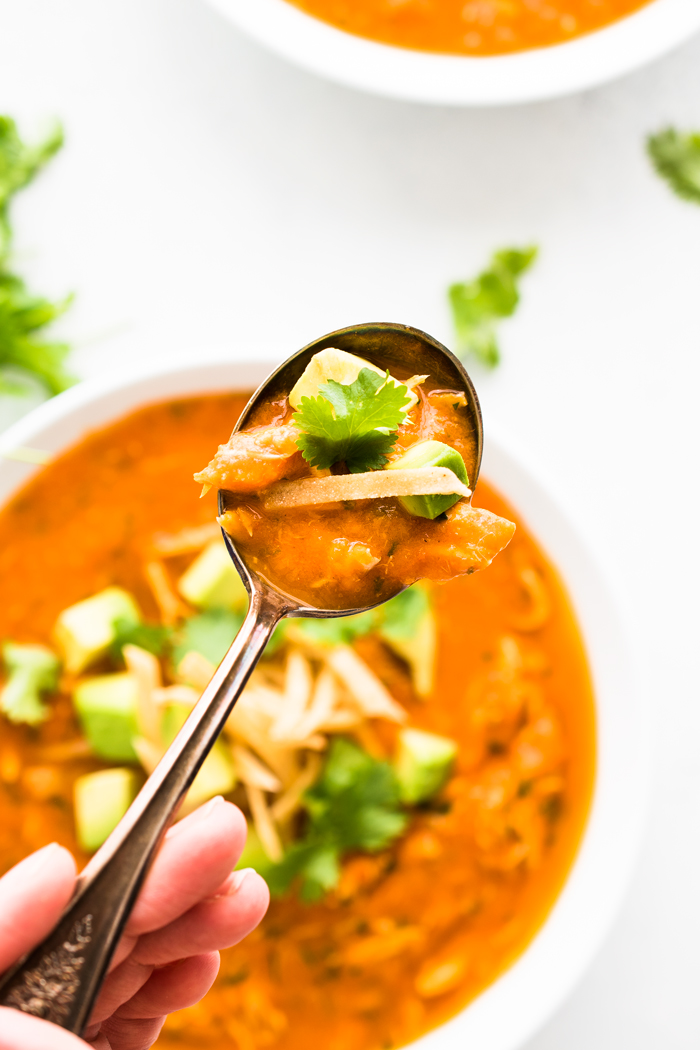 Easy and healthy Chicken Tortilla Soup made with fresh tomatoes and topped with avocado and crispy tortilla strips. 