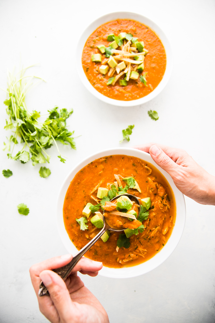 Easy and healthy Chicken Tortilla Soup made with fresh tomatoes and topped with avocado and crispy tortilla strips. 